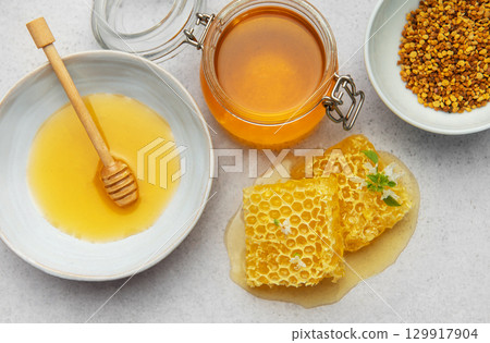 Composition of honey, honeycombs and bee pollen creating delicious golden spread 129917904