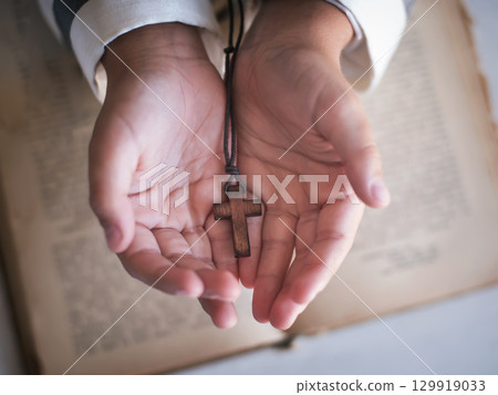 Cross in the child's hand. 129919033
