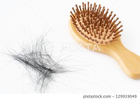 Bamboo hairbrush and loose hair on white background 129919049