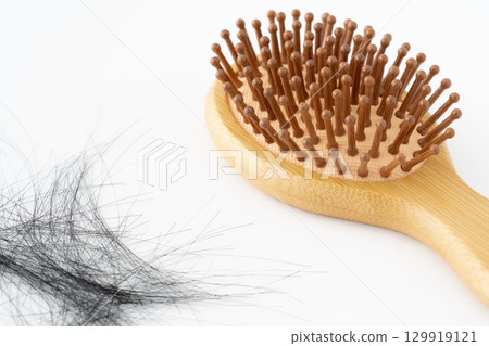 Bamboo hairbrush and loose hair on white background Bamboo hairbrush and loose hair on white background 129919121