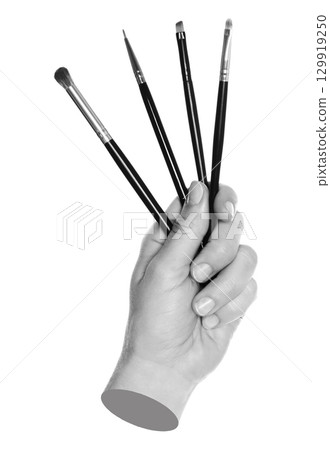 Woman hand holds black cosmetics brushes, isolated on transparent background, cosmetics and visage concept. Contemporary art Woman hand holds black cosmetics brushes, isolated on transparent background, cosmetics and visage concept. Contemporary art 129919250