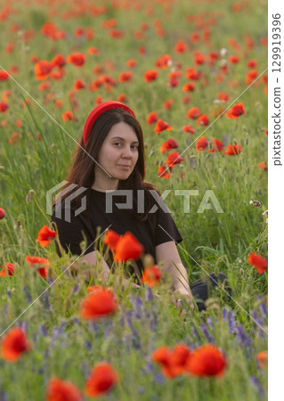 Young Woman in Poppy Field with Red Hat Young Woman in Poppy Field with Red Hat 129919396