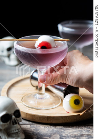 Halloween cocktail garnished with candy eye Halloween cocktail garnished with candy eye 129919706