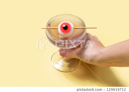 Halloween cocktail garnished with candy eye 129919712