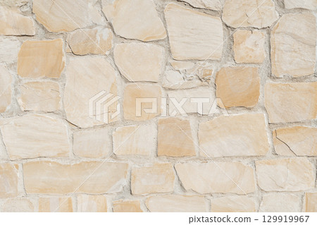Antique ancient stone wall masonry texture background. Old wall made of beige stone blocks  129919967