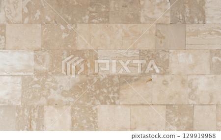 Antique ancient stone wall masonry texture background. Old wall made of beige stone blocks  129919968