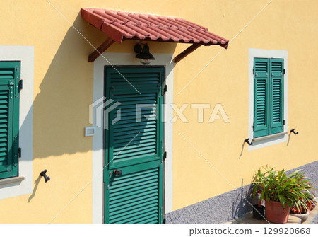 Traditional green doors and windows of Liguria. Tiled canopy. Traditional buildings of Italy. Copy space for design.  129920668