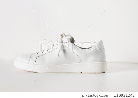 New white sneaker isolated on white background. Creative shoes modern style, fashion concept. Summer womens footwear. Copy space. New white sneaker isolated on white background. Creative shoes modern style, fashion concept. Summer womens footwear. Copy space. 129921242