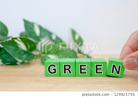 單字 GREEN 以綠色塊和樹葉背景排列 單字 GREEN 以綠色塊和樹葉背景排列 129921756