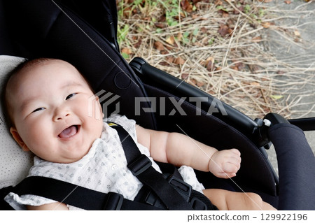A 5-month-old Japanese baby girl smiles in a stroller A 5-month-old Japanese baby girl smiles in a stroller 129922196