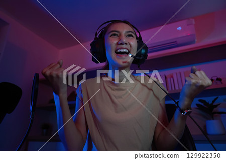 Gaming Enthusiast Celebrating Victory in a Colorful Room 129922350
