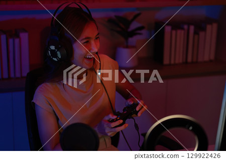 Joyful Gamer Celebrating Victory with Headset and Controller Joyful Gamer Celebrating Victory with Headset and Controller 129922426