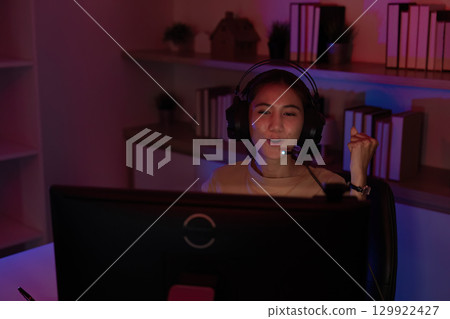 Joyful Gamer Celebrating Win in Home Office 129922427