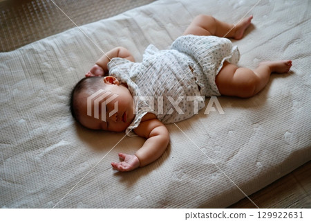 Five-month-old Japanese baby girl sleeping in a cheery pose Five-month-old Japanese baby girl sleeping in a cheery pose 129922631