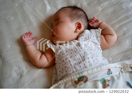 Five-month-old Japanese baby girl sleeping in a cheery pose Five-month-old Japanese baby girl sleeping in a cheery pose 129922632