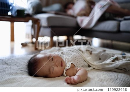 一個 5 個月大的嬰兒在陽光明媚的窗邊小睡 129922638