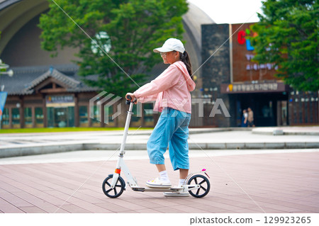 Asian girl is going to ride a scooter. Copy space Asian girl is going to ride a scooter. Copy space 129923265