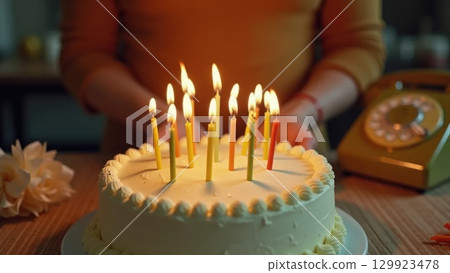 Vintage 1970s Birthday Celebration Hands Blowing Out Candles on Cake 129923478