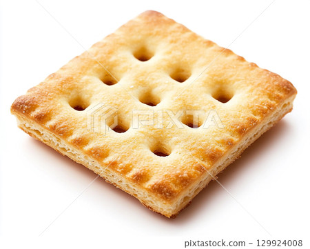 A close-up shot of a small pile of square creme crackers stacked against a plain white background. The crackers are golden-brown with small holes on their surface. 129924008