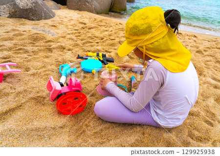Asian girl play toys in the beach. The concept of holiday activities. 129925938