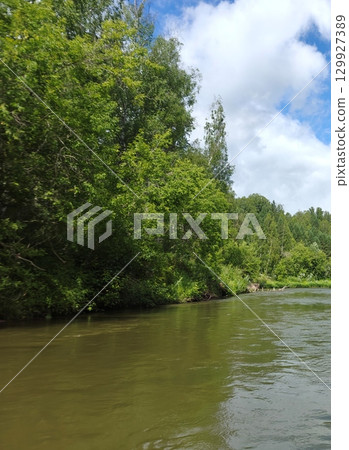 Scenic River Landscape with Lush Greenery and Clear Sky, Perfect for Outdoor Adventures Scenic River Landscape with Lush Greenery and Clear Sky, Perfect for Outdoor Adventures 129927389