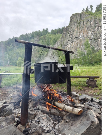 Cooking over a Campfire in the Wilderness A Rustic and Heartwarming Outdoor Experience. 129927395