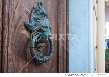 Door knocker on wooden door in traditional house. Vintage element on building. Door knocker on wooden door in traditional house. Vintage element on building. 129927396
