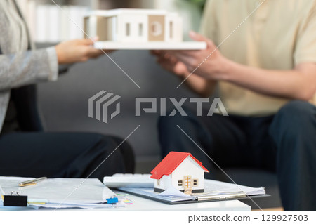 Real Estate Agent Presenting Model House to Client Real Estate Agent Presenting Model House to Client 129927503