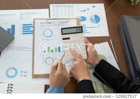 Financial advisor calculating monthly budget with client Financial advisor calculating monthly budget with client 129927517