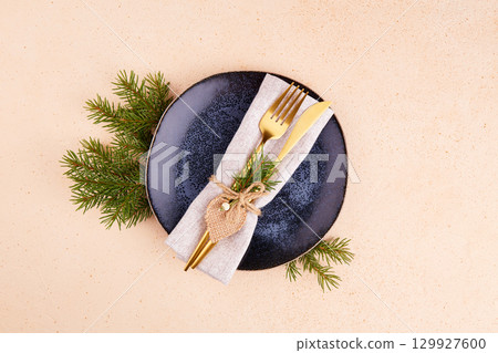 Christmas table setting. Vintage plate, silverware, fir branches, festive decor. Christmas table setting. Vintage plate, silverware, fir branches, festive decor. 129927600