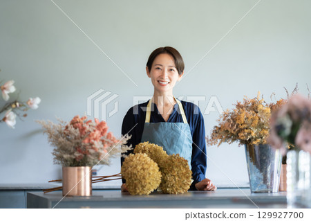 A woman living surrounded by flowers 129927700