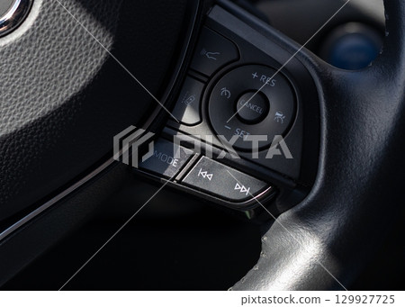 Car steering wheel control buttons close-up 129927725