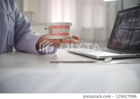 Female Dentist working in office 129927996