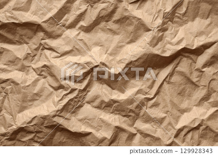Recycle brown paper crumpled texture. Wrapping craft old paper surface for background. Crinkled Kraft Sheet. Textured Cardboard Backdrop. Full frame. Copy space. Concept of using recycled materials. 129928343