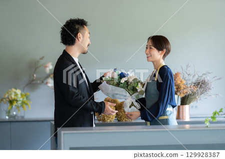 Male customer buying flowers at a flower shop 129928387