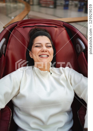 Relaxing experience in a contemporary massage chair at the mall 129929039