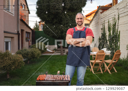 Enjoying a summer barbecue with friends in a cozy backyard setting 129929087