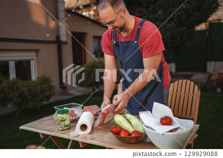 Enjoying a sunny afternoon preparing a fresh garden meal outside 129929088
