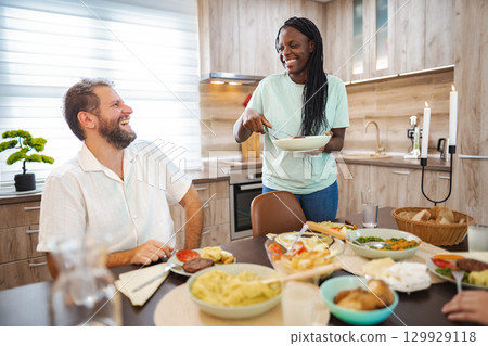 Enjoying a joyful meal together in a modern kitchen space 129929118