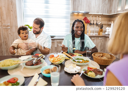 Joyful family gathering around a delicious homemade dinner 129929120