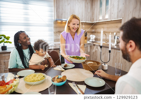 Family gathering sharing a joyful meal at home 129929123