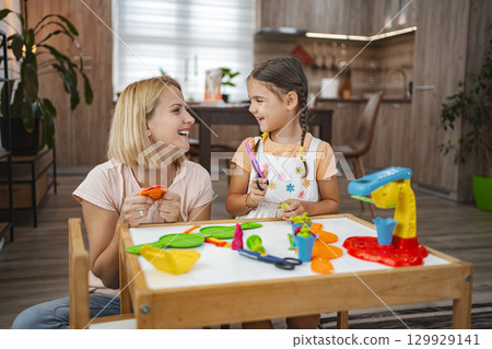 Daughter and mother play together with plasticine modeling 129929141