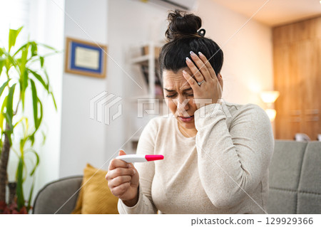 Woman feeling worried after doing a pregnancy test Woman feeling worried after doing a pregnancy test 129929366