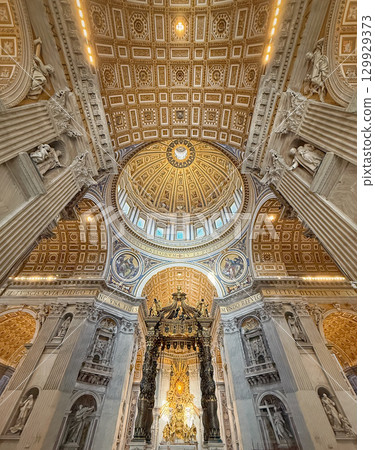 Ornate, gilded dome and ceiling of St. Peter's Basilica, features a golden sunburst design, decorated with intricate mosaics and paintings. Luxurious decoration of the Vatican iconic interior 129929373