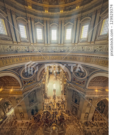 VATICAN CITY, VATICAN - JULY 31, 2025 An elevated view shows the vast, crowded nave of St. Peter's Basilica. The magnificent vaulted ceiling creates a stunning architectural masterpiece VATICAN CITY, VATICAN - JULY 31, 2025 An elevated view shows the vast, crowded nave of St. Peter's Basilica. The magnificent vaulted ceiling creates a stunning architectural masterpiece 129929374