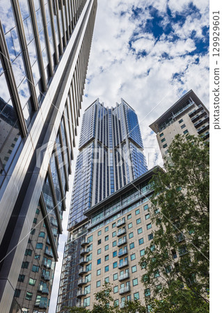 Low angle view of glass skyscraper and surrounding towers 129929601