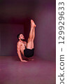 Man holds advanced balance pose on hands with straight lifted legs. Concept of strength, balance, focus, endurance, discipline and physical mastery. 129929633