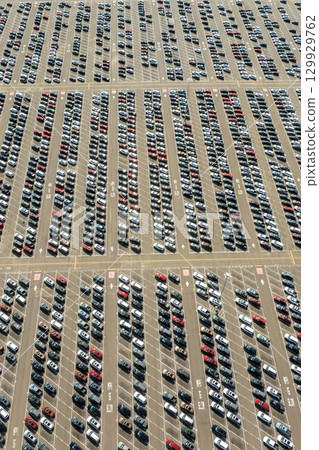 Parked new cars at the automotive plant factory parking lot ready for sale. Development of American industry concept Parked new cars at the automotive plant factory parking lot ready for sale. Development of American industry concept 129929762