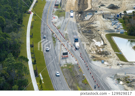 Driving traffic cars on road under construction. Building traffic infrastructure on American roadway with moving cars 129929817