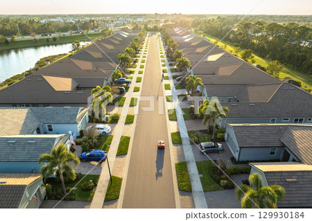 Premium housing development in the USA. Expensive houses between green palm trees in southwest Florida Premium housing development in the USA. Expensive houses between green palm trees in southwest Florida 129930184